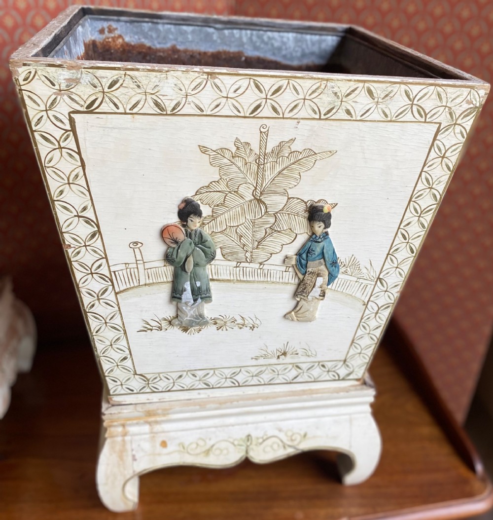 A pair of square cream painted wooden planters featuring raised figural motifs and banana palm tree designs on stepped bases with removable metal liners. View III