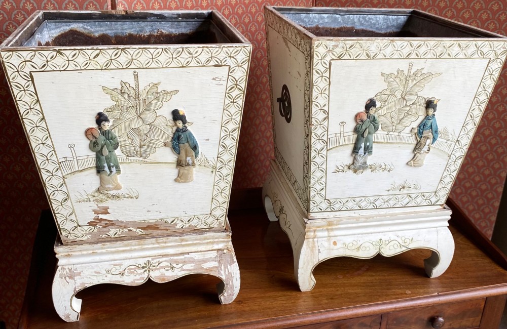 A pair of square cream painted wooden planters featuring raised figural motifs and banana palm tree designs on stepped bases with removable metal liners. View VI