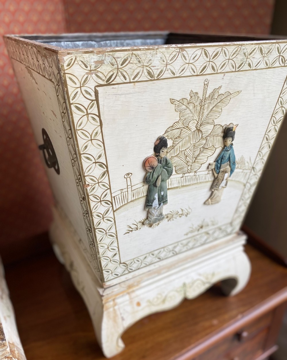 A pair of square cream painted wooden planters featuring raised figural motifs and banana palm tree designs on stepped bases with removable metal liners. View VII