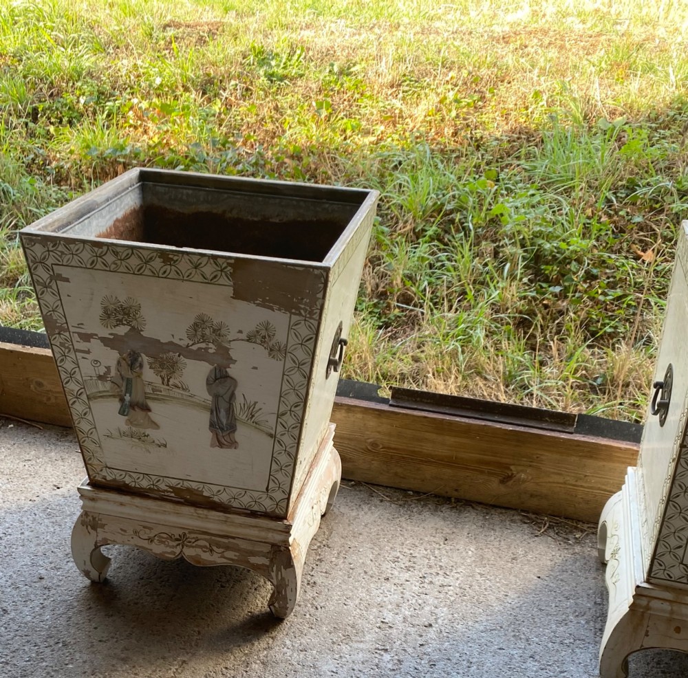 A pair of square cream painted wooden planters featuring raised figural motifs and banana palm tree designs on stepped bases with removable metal liners. View VIII