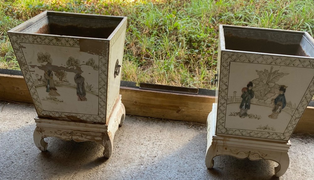 A pair of square cream painted wooden planters featuring raised figural motifs and banana palm tree designs on stepped bases with removable metal liners. View X