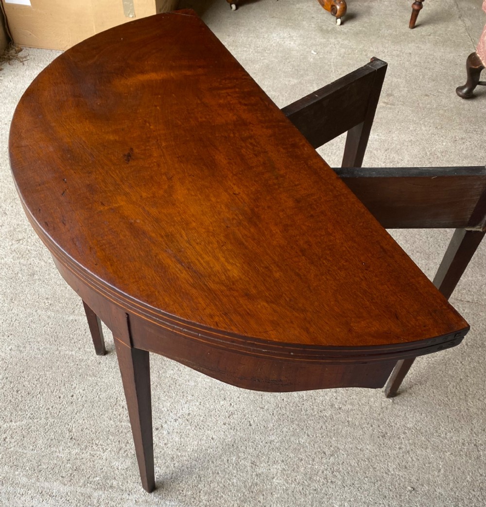 An 18th-century mahogany demilune tea table featuring a semi-circular fold-over top and four slender tapered legs. View IV