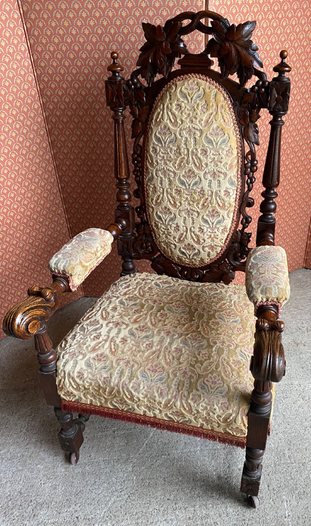 A 19th-century carved dark oak armchair with an oval upholstered backrest, ornate leaf cresting, and scrolled armrests. View VI