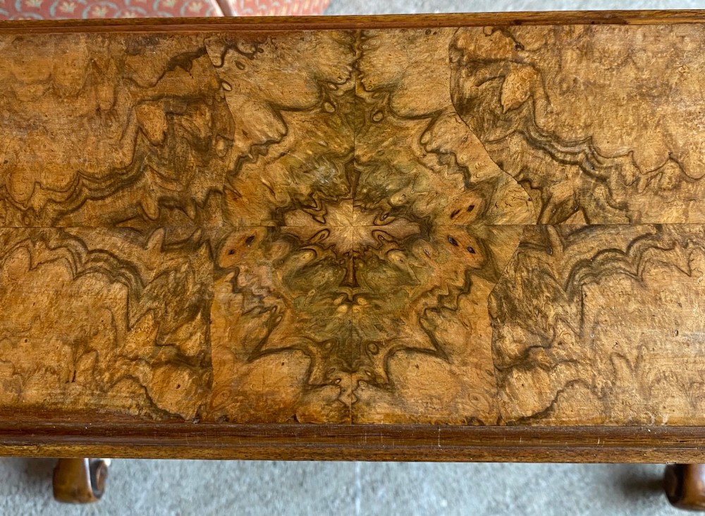 A Victorian burr walnut drop leaf table with turned twin column supports, a stretchered base, scrolled feet on brass castors, and a figured veneer surface. View II