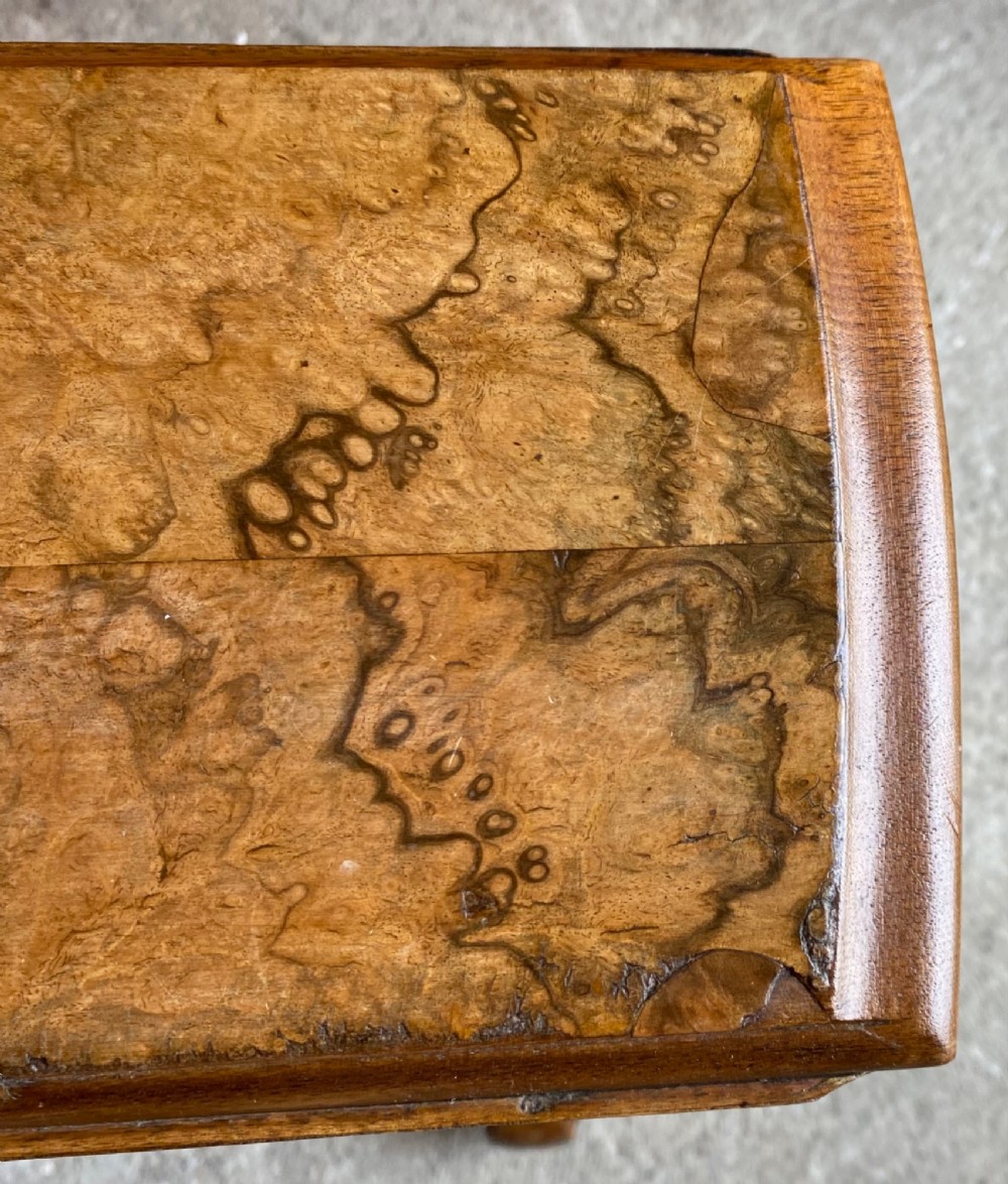 A Victorian burr walnut drop leaf table with turned twin column supports, a stretchered base, scrolled feet on brass castors, and a figured veneer surface. View III