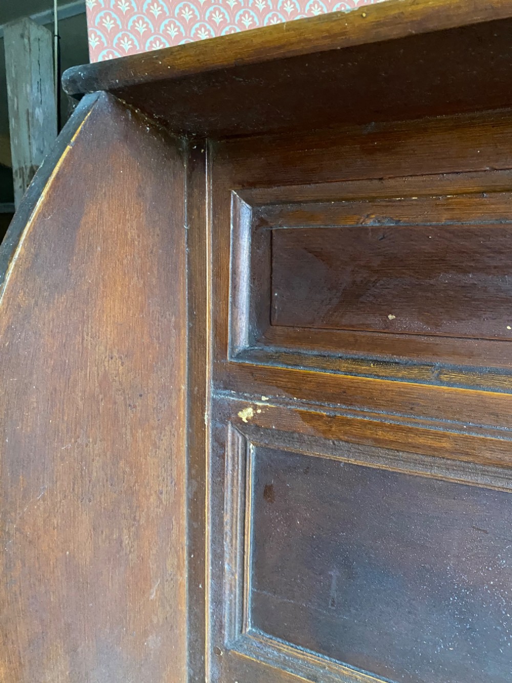 An 18th-century high-backed wooden settle featuring multi-panelled backboards, wing sides, and a lift-up box seat base with rich brown patina. View V