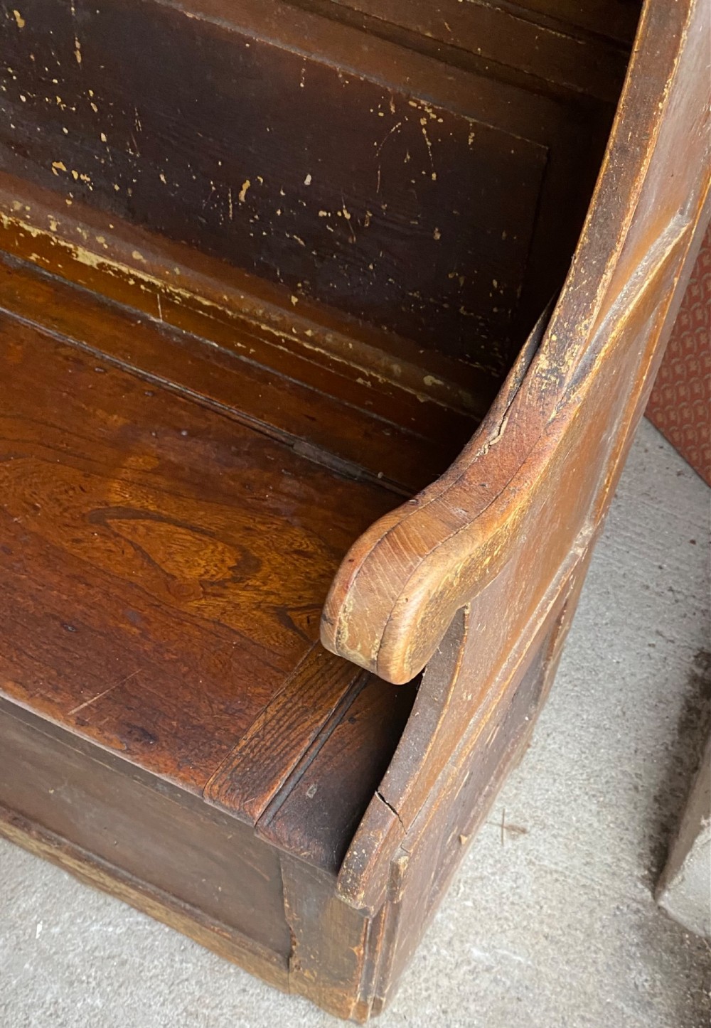An 18th-century high-backed wooden settle featuring multi-panelled backboards, wing sides, and a lift-up box seat base with rich brown patina. View VII