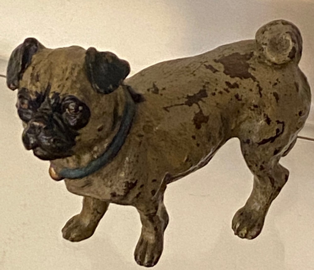An antique cold-painted bronze desk inkwell designed in the realistic form of a standing pug dog with a blue collar.