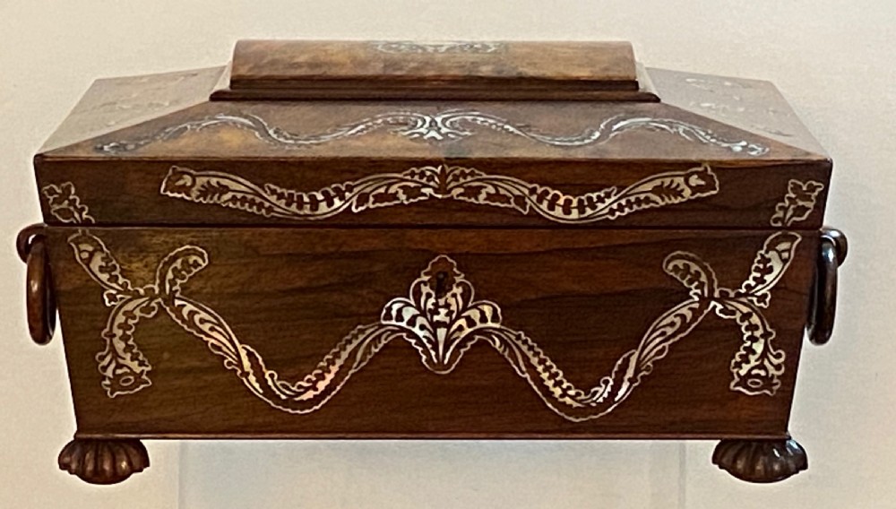A Regency rosewood workbox with mother-of-pearl foliate inlays, side ring handles, and carved feet. View II