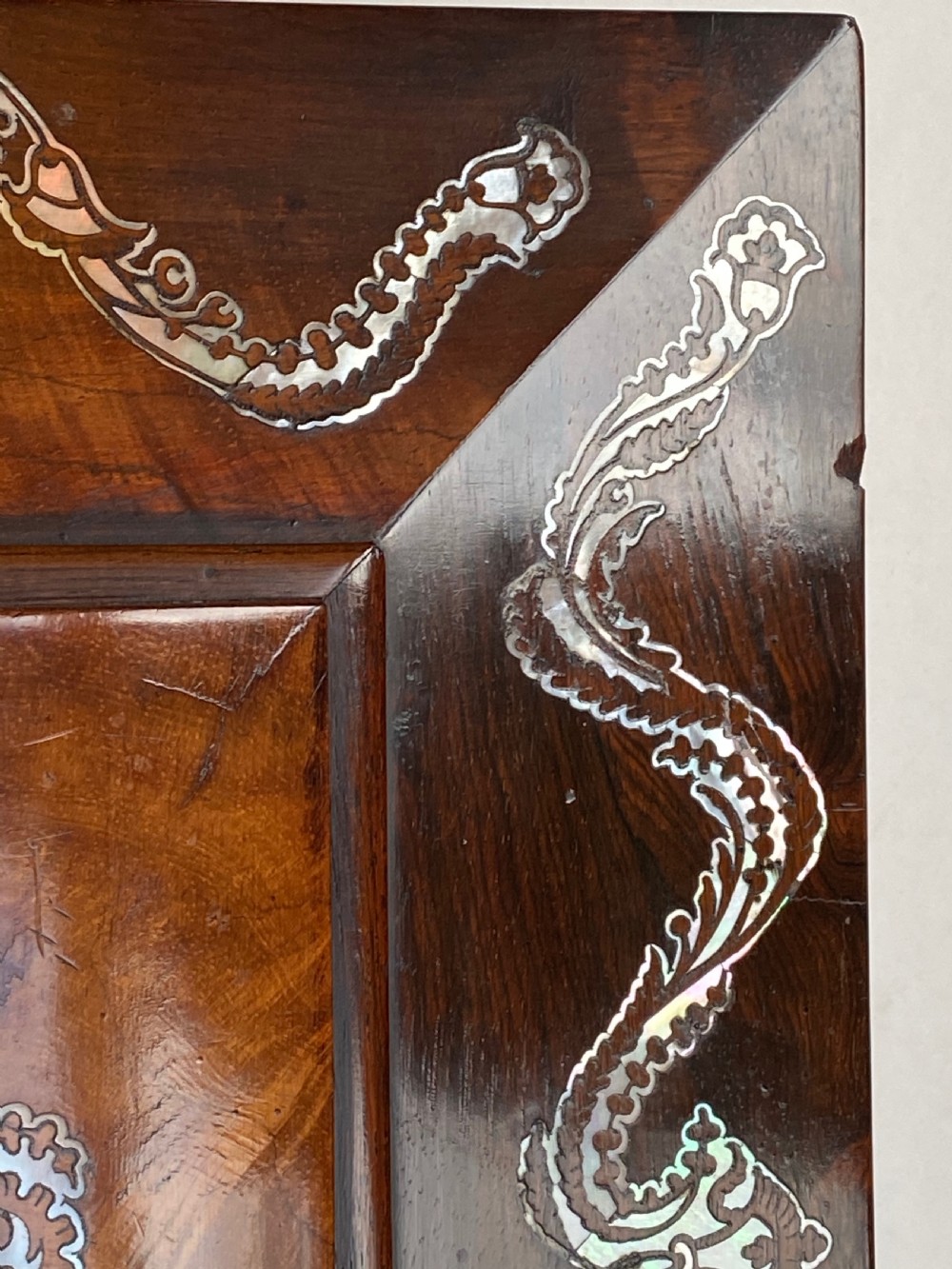 A Regency rosewood workbox with mother-of-pearl foliate inlays, side ring handles, and carved feet. View IV