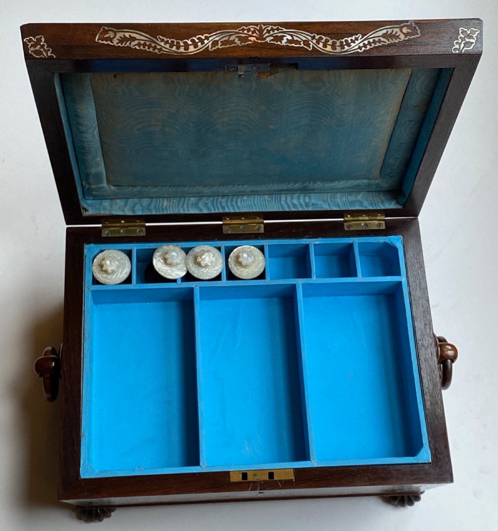A Regency rosewood workbox with mother-of-pearl foliate inlays, side ring handles, and carved feet. View VII