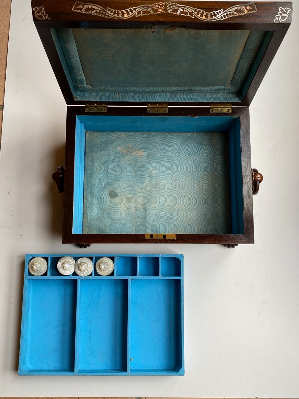 A Regency rosewood workbox with mother-of-pearl foliate inlays, side ring handles, and carved feet. View VIII