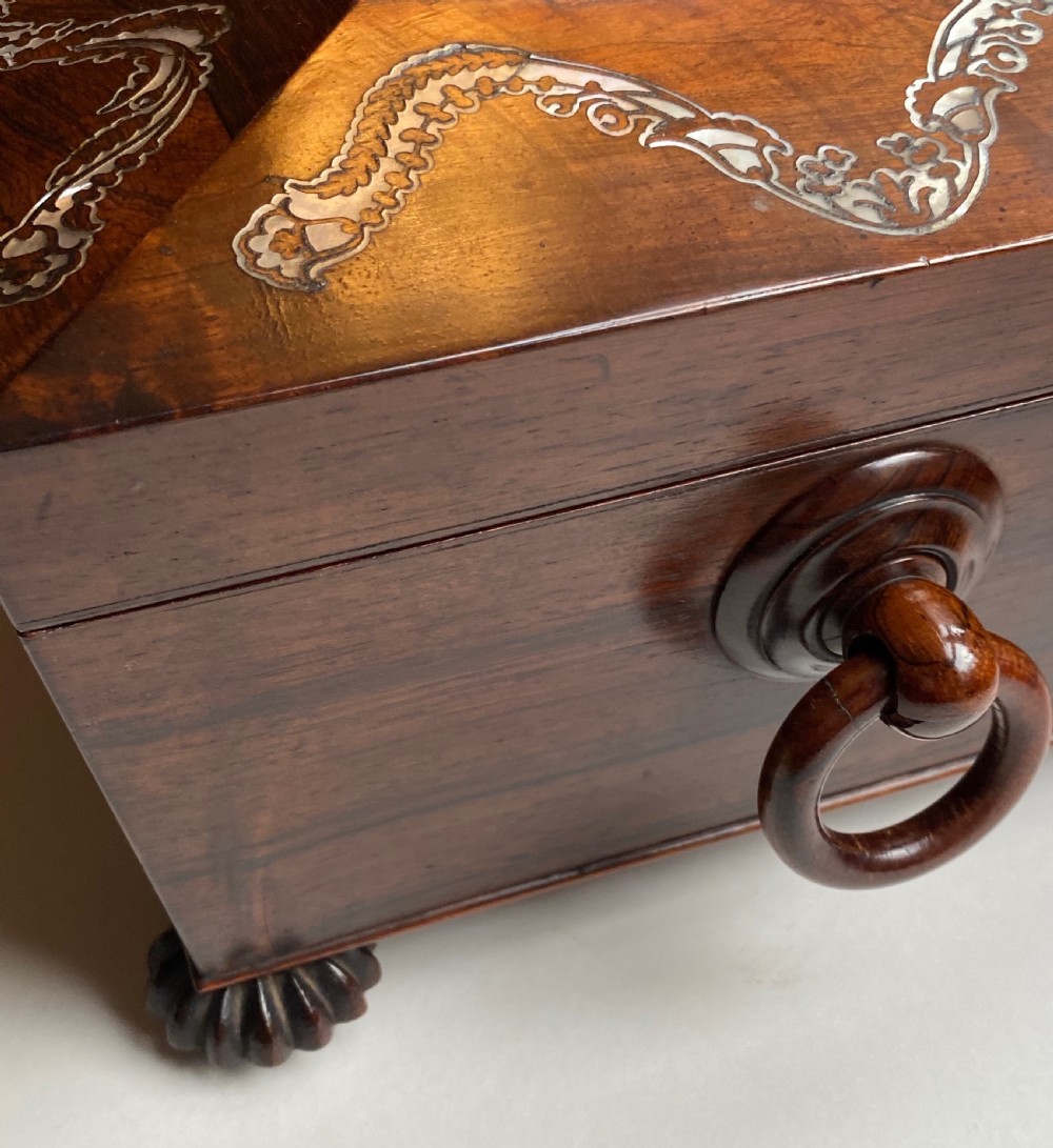 A Regency rosewood workbox with mother-of-pearl foliate inlays, side ring handles, and carved feet. View XII