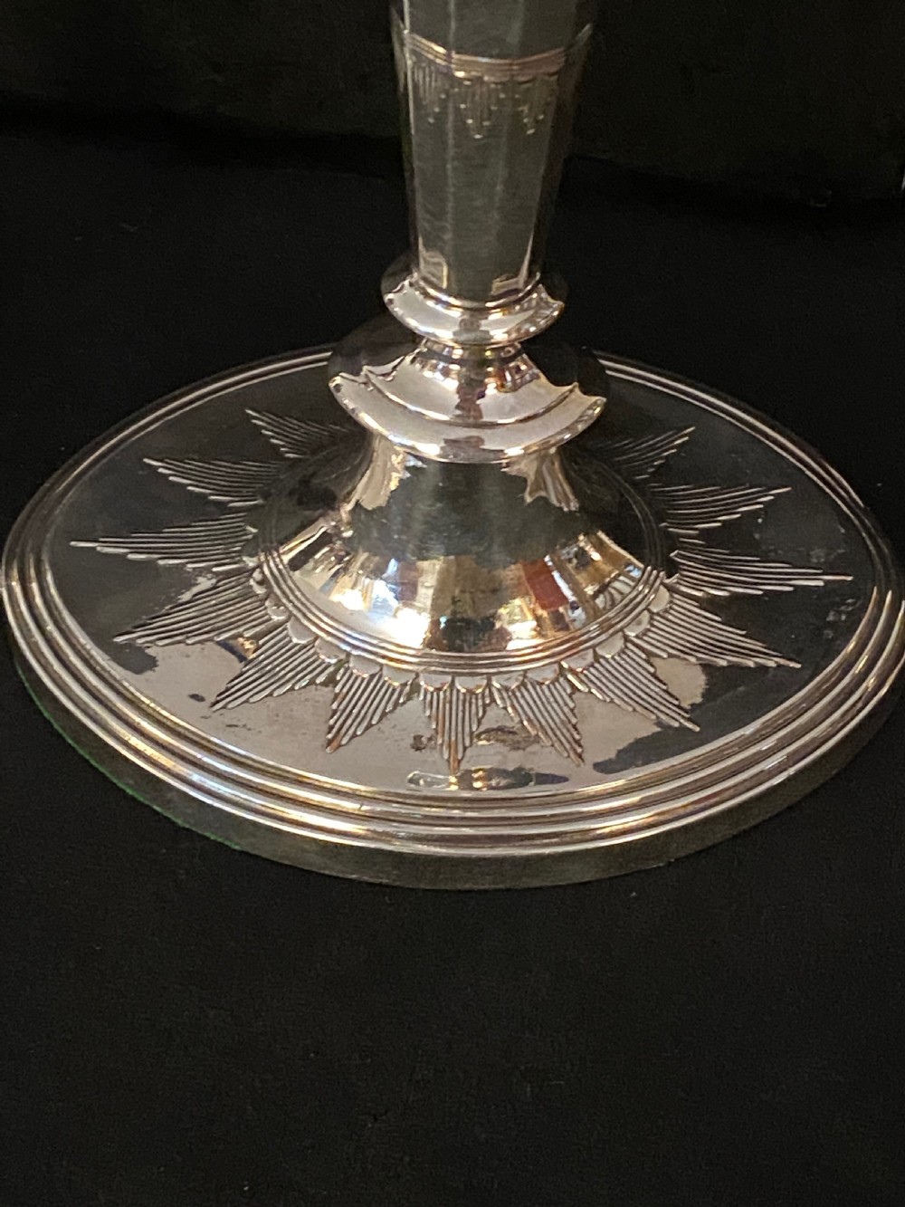 A pair of George III silver-plated candlesticks featuring faceted tapering shafts and circular stepped bases holding white candles. View IV