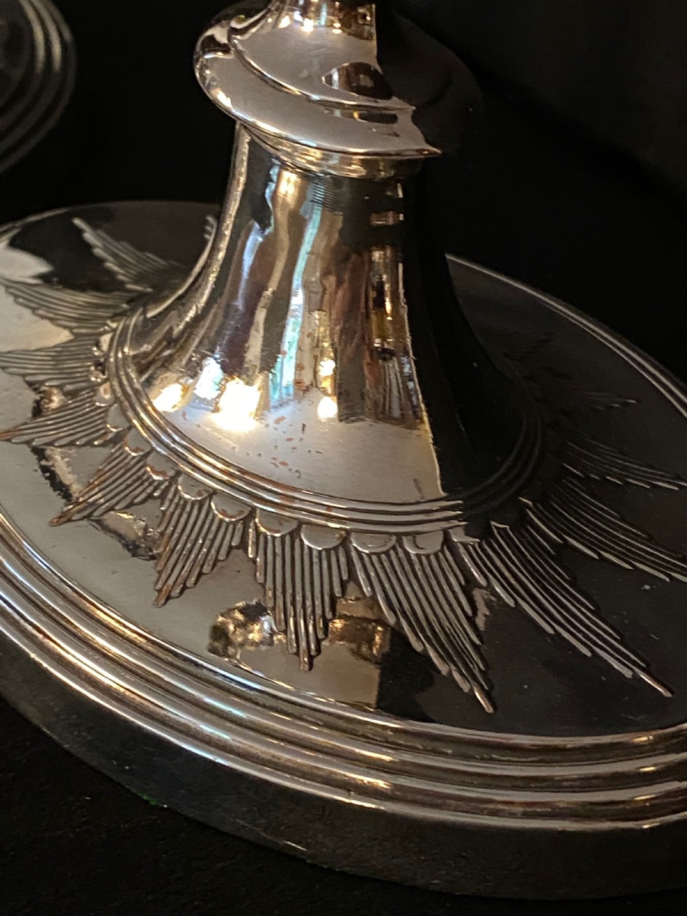 A pair of George III silver-plated candlesticks featuring faceted tapering shafts and circular stepped bases holding white candles. View VI