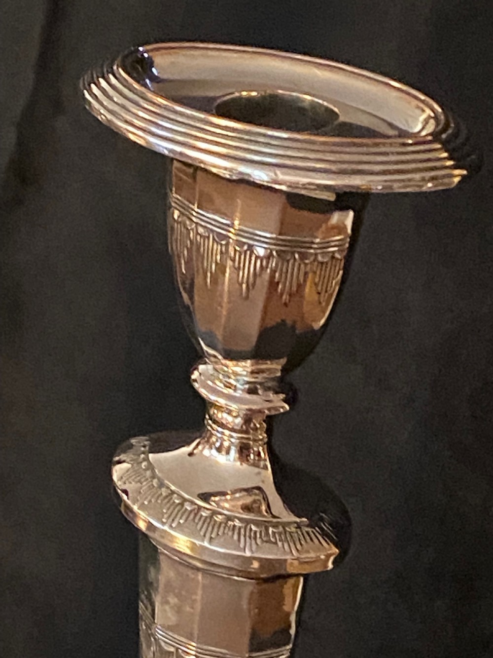 A pair of George III silver-plated candlesticks featuring faceted tapering shafts and circular stepped bases holding white candles. View VII