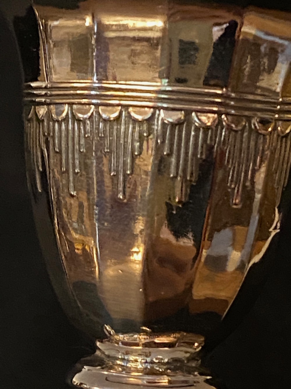 A pair of George III silver-plated candlesticks featuring faceted tapering shafts and circular stepped bases holding white candles. View VIII