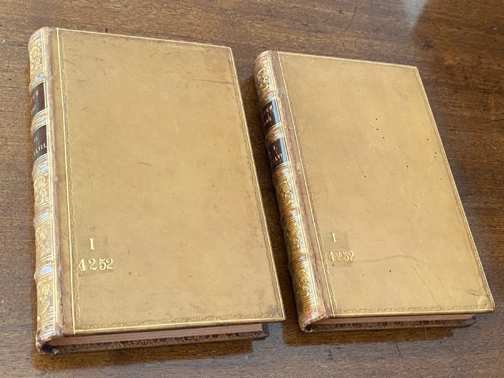 A two-volume set of tan leather-bound antique books titled Bewicks Birds with elaborate gold gilt tooling on the spines. View V