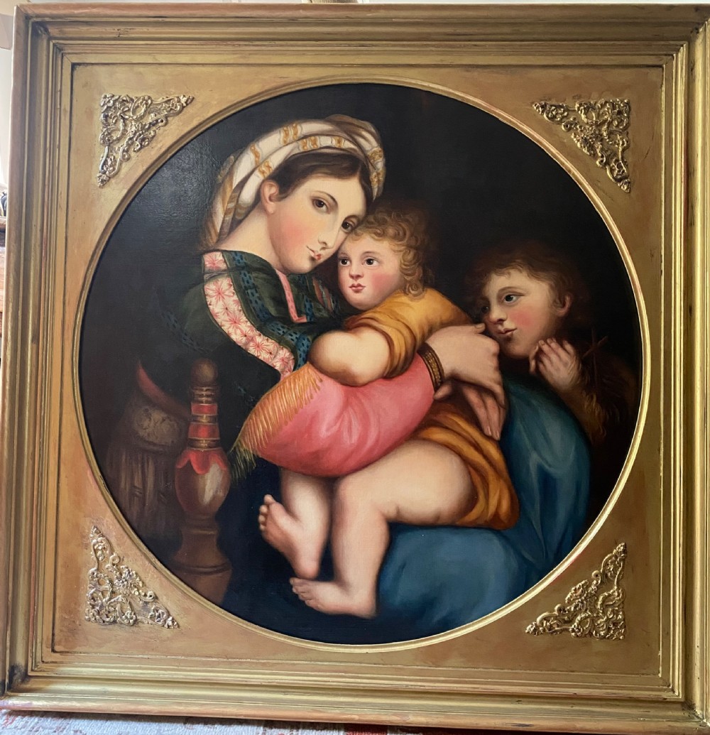An antique square gilded frame housing a circular tondo oil painting depicting the Madonna embracing the Christ child alongside Saint John the Baptist.