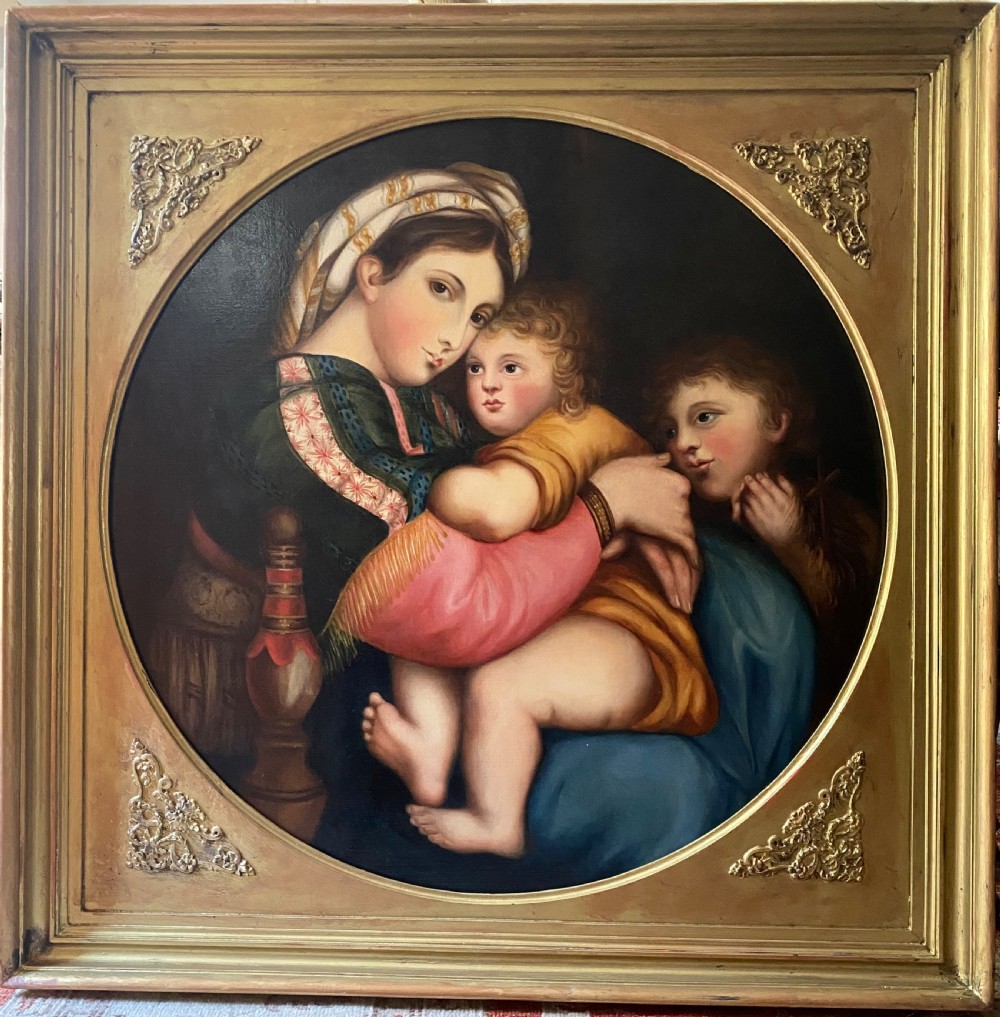 An antique square gilded frame housing a circular tondo oil painting depicting the Madonna embracing the Christ child alongside Saint John the Baptist. View II
