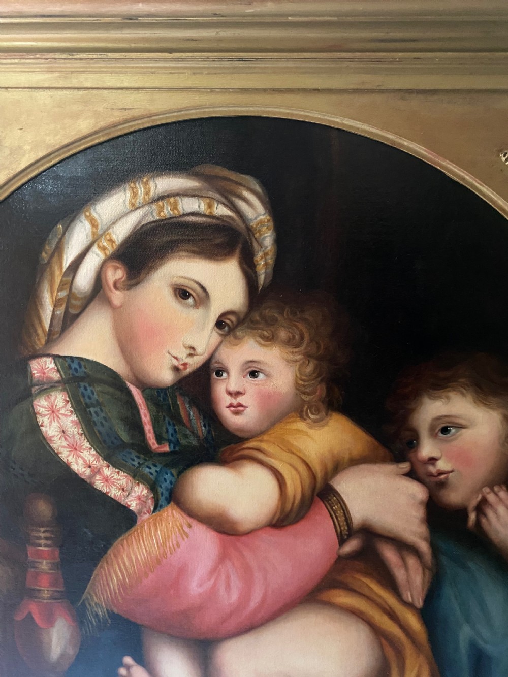 An antique square gilded frame housing a circular tondo oil painting depicting the Madonna embracing the Christ child alongside Saint John the Baptist. View III
