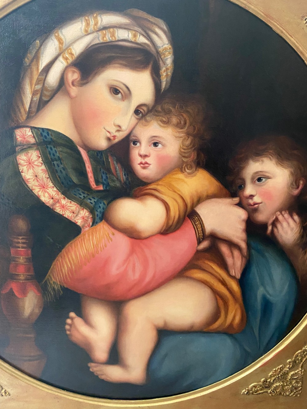 An antique square gilded frame housing a circular tondo oil painting depicting the Madonna embracing the Christ child alongside Saint John the Baptist. View VII