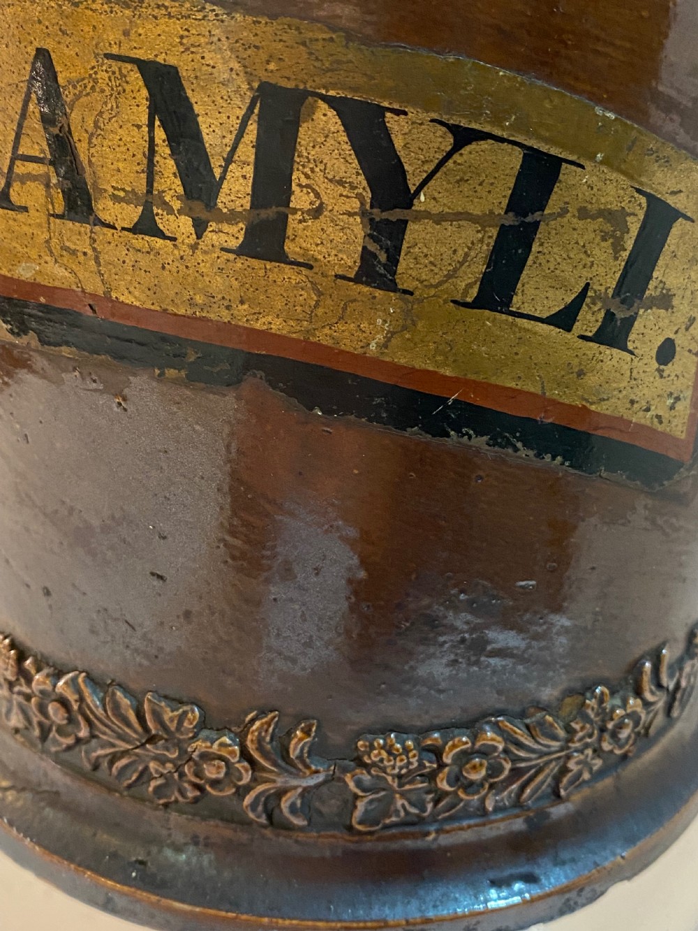 A mid-19th century brown glazed stoneware apothecary jar featuring floral relief borders and a label reading PULV AMYLI. View IX