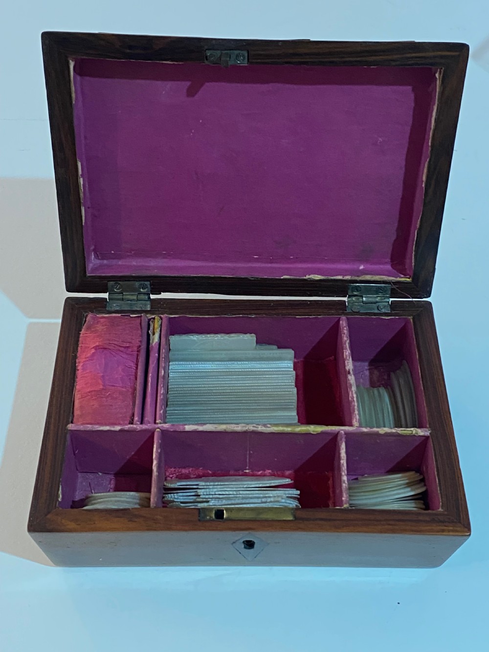A rectangular wooden box featuring geometric parquetry inlay in contrasting shades of brown wood with a keyhole on the front. View VII