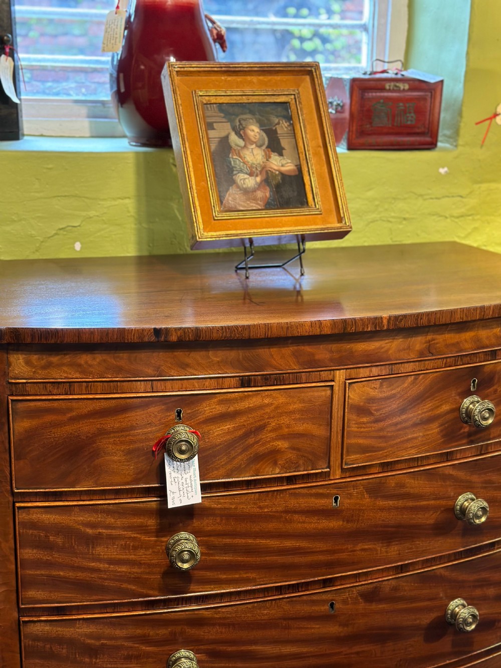 A large Regency mahogany bowfront chest featuring two short over three long graduated drawers with decorative brass turned handles on splayed feet. View X