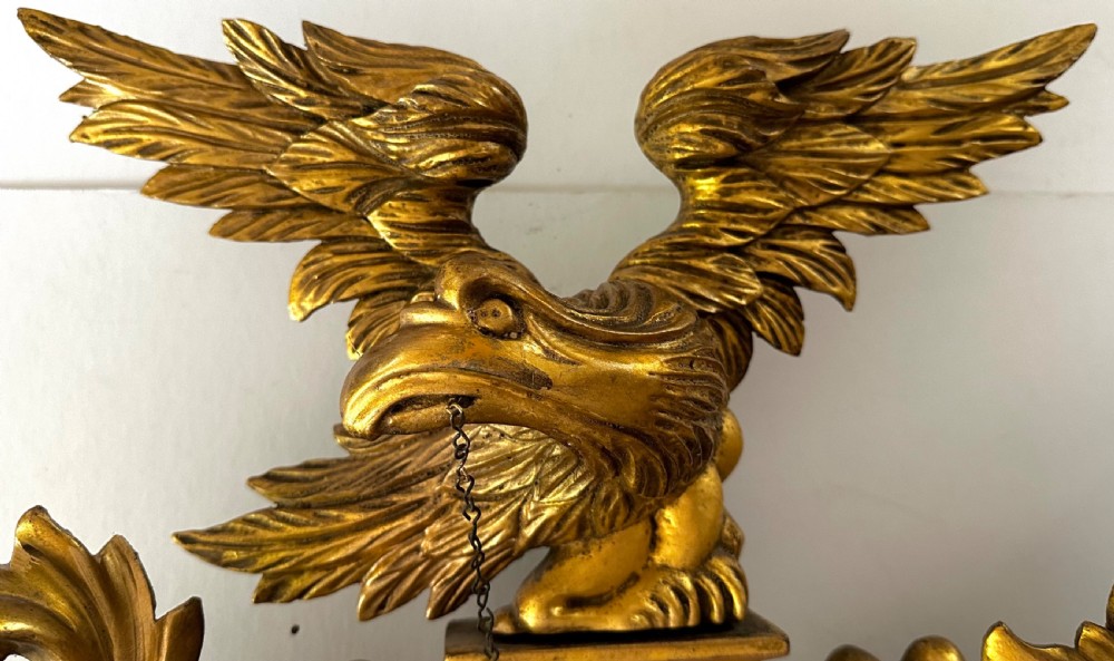 A circular Regency giltwood convex mirror featuring a carved eagle cresting, acanthus leaf scrolls, and ball mouldings around an ebonised inner slip. View III