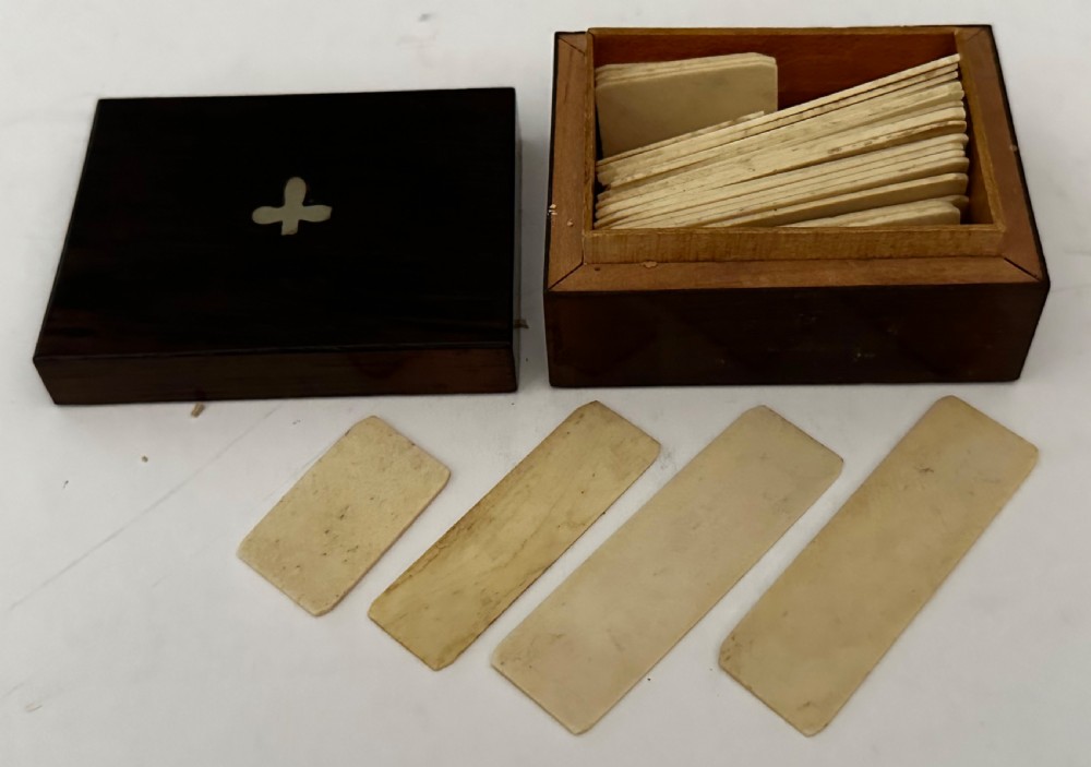 A rectangular dark rosewood games box featuring mother-of-pearl and abalone inlaid borders with a central playing card motif medallion and a brass keyhole. View VIII