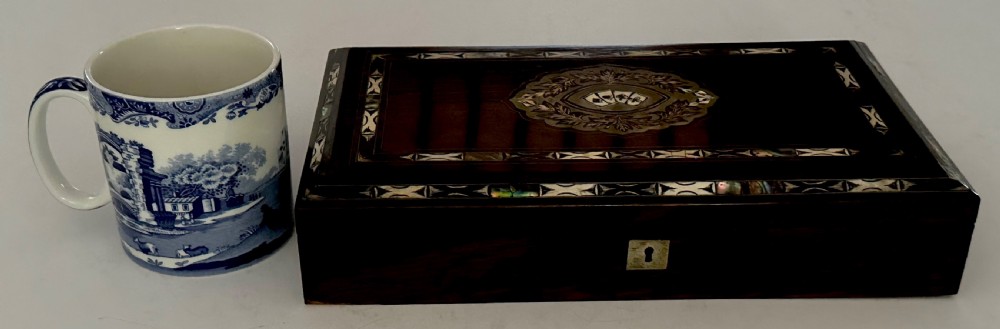 A rectangular dark rosewood games box featuring mother-of-pearl and abalone inlaid borders with a central playing card motif medallion and a brass keyhole. View XIV