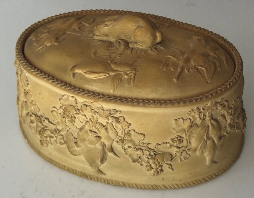 An oval buff-coloured ceramic game pie dish featuring relief mouldings of game birds, foliage, and a hare finial on the lid. View III