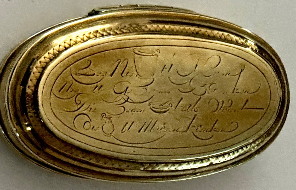 An 18th-century oval brass tobacco box featuring hand-engraved Dutch calligraphy and a hinged lid. View III