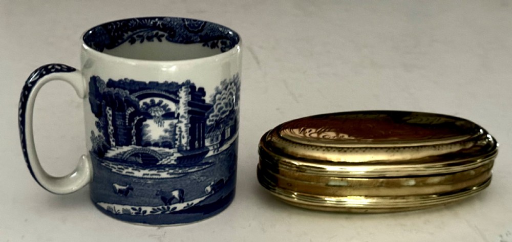 An 18th-century oval brass tobacco box featuring hand-engraved Dutch calligraphy and a hinged lid. View VIII