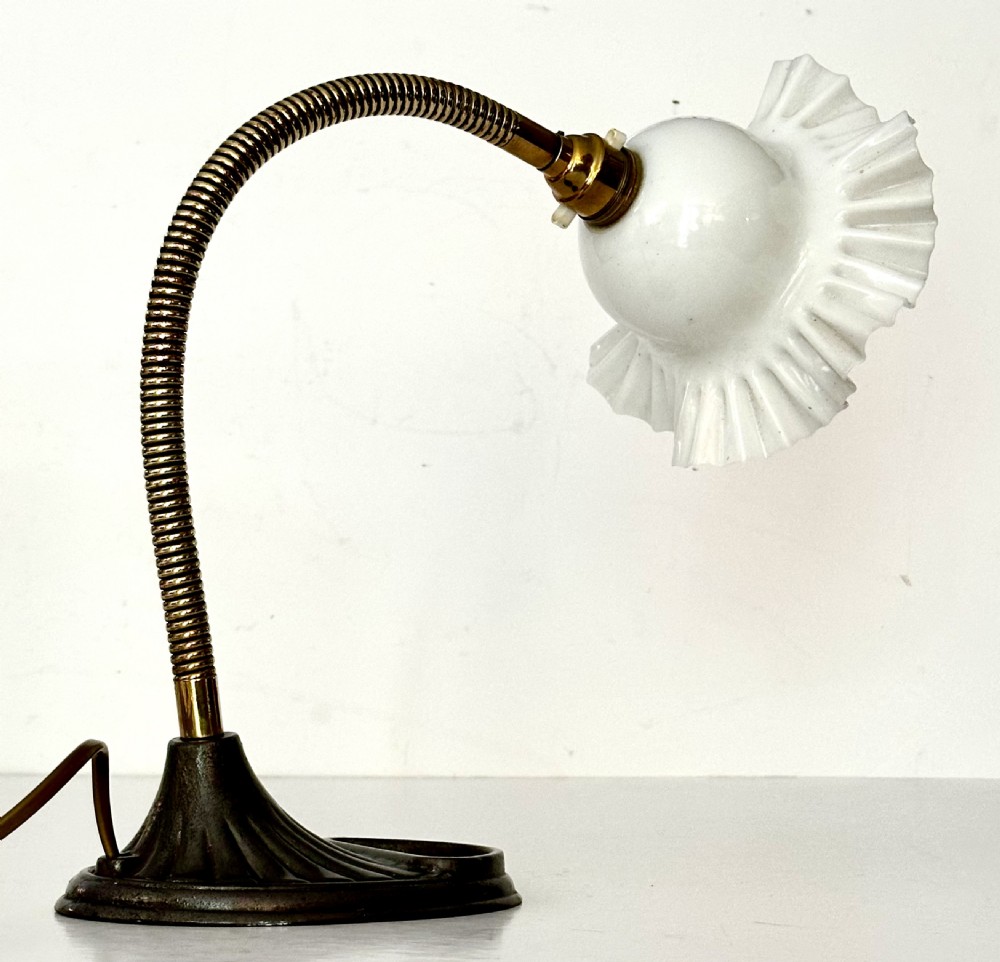 A brass gooseneck desk lamp with a flexible coiled arm, dark cast base featuring a built-in tray, and a ruffled white glass shade. View III