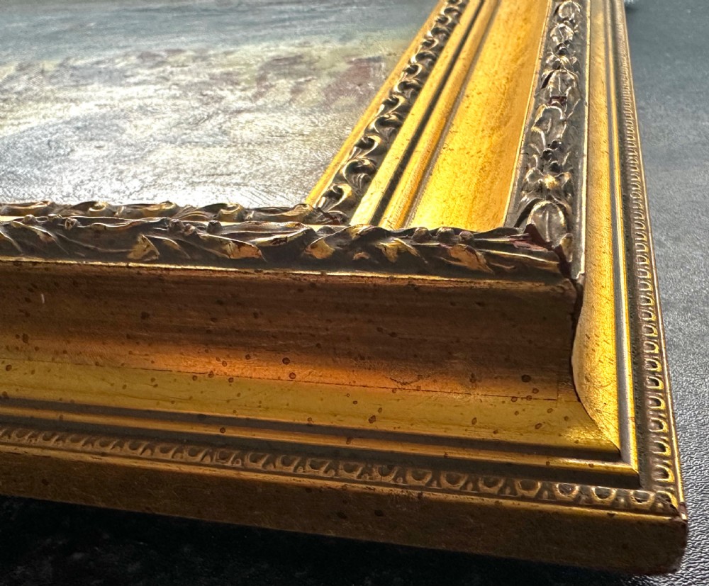 An impressionist oil painting depicting crowds of figures gathered on a sandy beach beside a blue sea, presented in an ornate gold gilt frame. View VII
