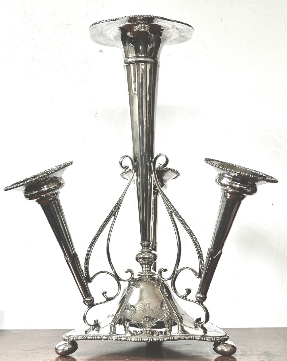 A silver-plated four-trumpet epergne table centrepiece featuring a central flared vase and three smaller removable side vases on a scrolled base. View II
