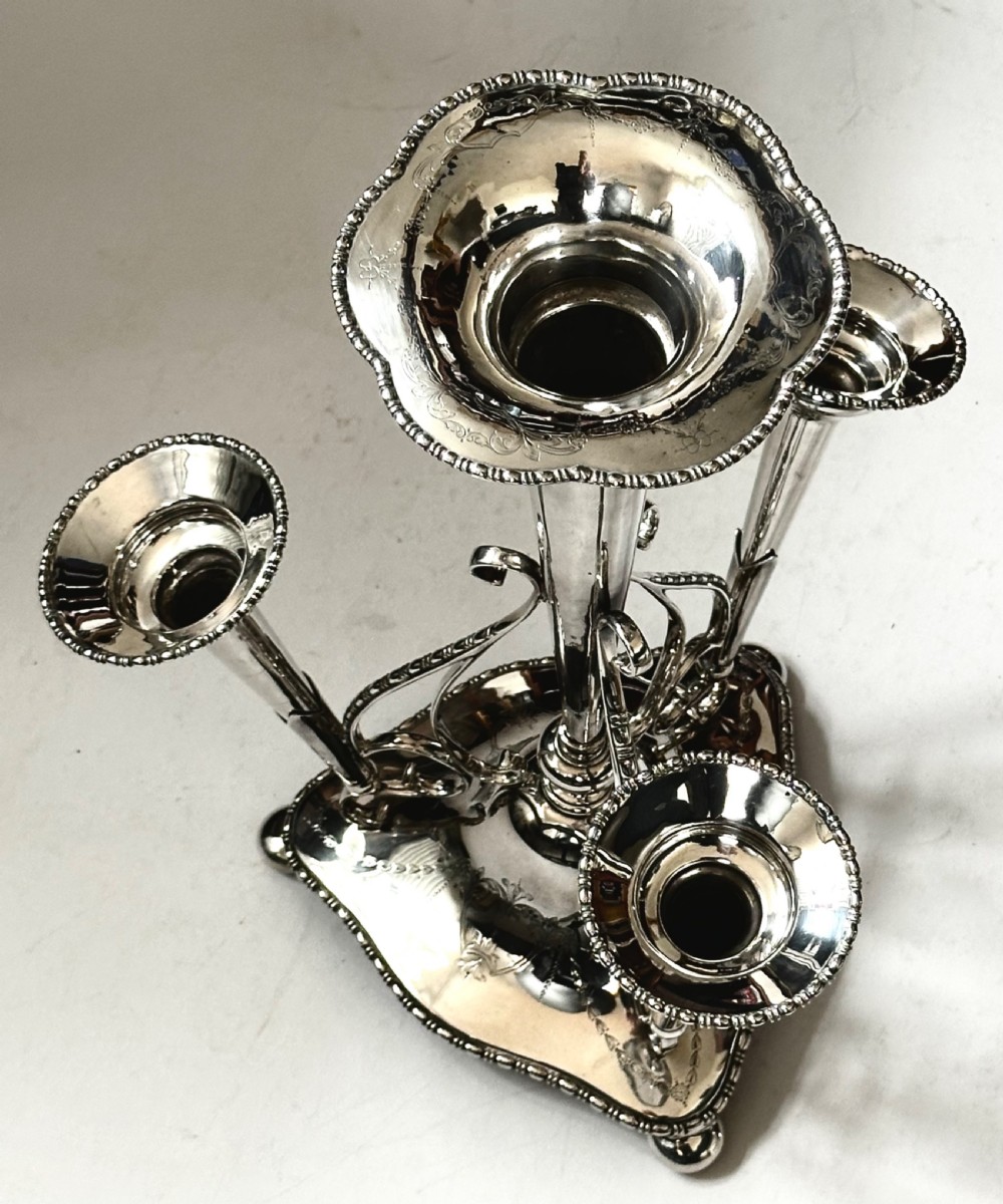 A silver-plated four-trumpet epergne table centrepiece featuring a central flared vase and three smaller removable side vases on a scrolled base. View VIII