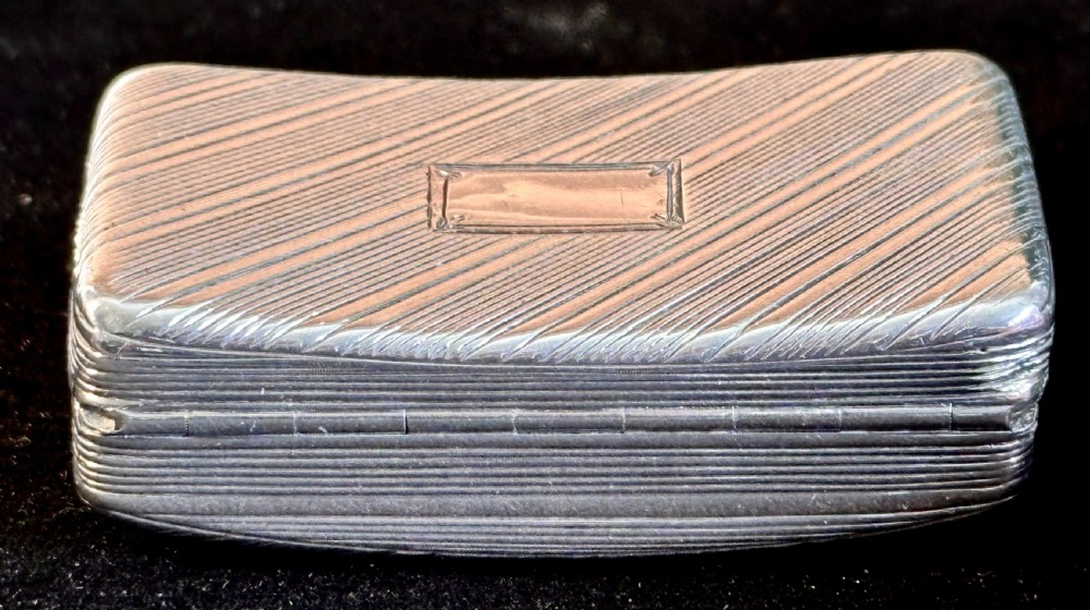 A rectangular antique silver snuff box featuring diagonal engine-turned reeding and a central unengraved rectangular cartouche. View V