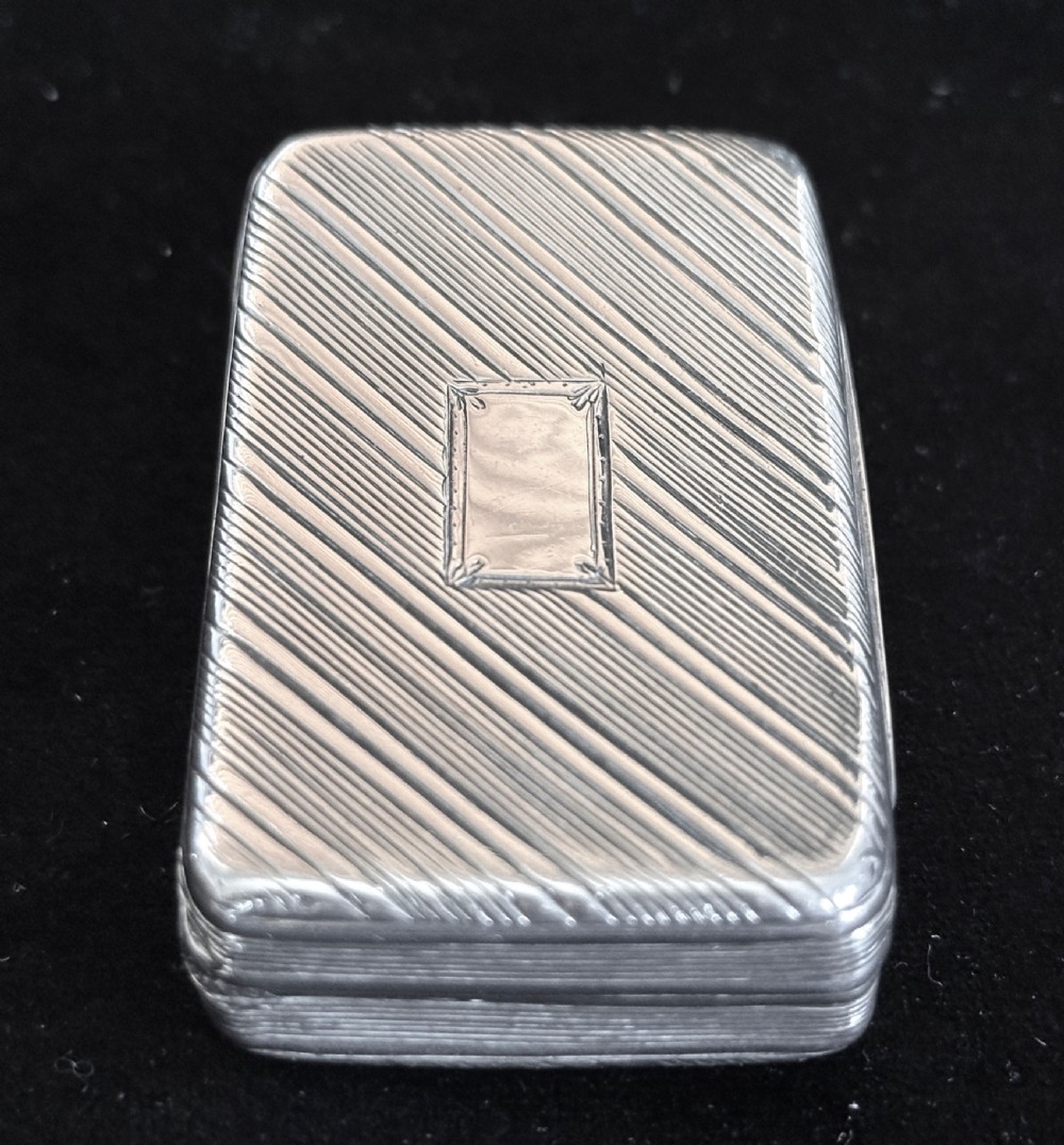 A rectangular antique silver snuff box featuring diagonal engine-turned reeding and a central unengraved rectangular cartouche. View XII