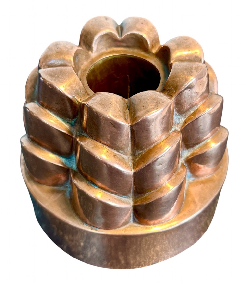 A Victorian copper jelly mould featuring a tiered castle design with fluted column detailing and a smooth circular base. View II