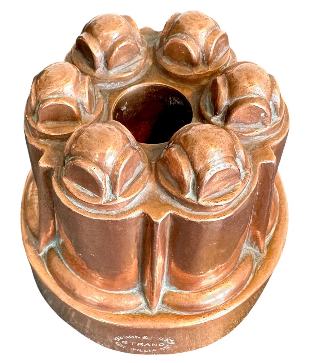 A Victorian stamped copper jelly mould featuring a multi-columned tiered architectural design with a central aperture. View III