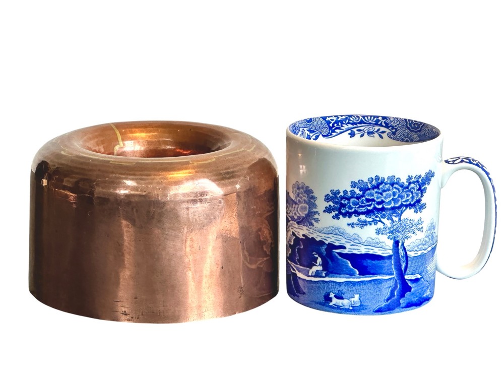 A cylindrical polished copper jelly mould with a smooth exterior and central ring well. View V