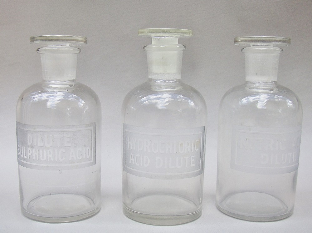 UNUSUAL SET OF THREE EARLY 20TH CENTURY ETCHED GLASS CHEMISTRY BOTTLES, CIRCA 1920
