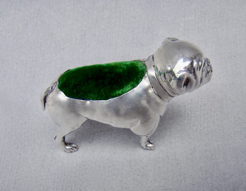 An Edwardian sterling silver pin cushion cast in the shape of a standing bulldog with a green velvet insert in its back. View II