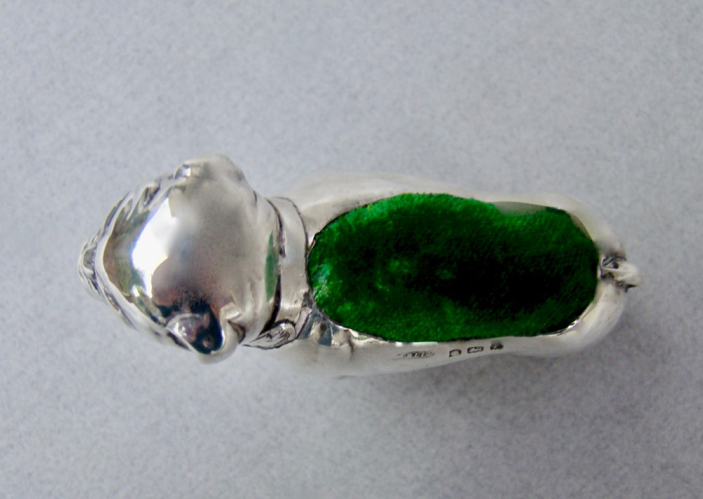 An Edwardian sterling silver pin cushion cast in the shape of a standing bulldog with a green velvet insert in its back. View IV