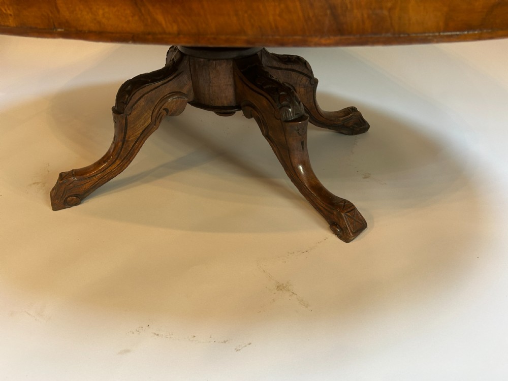 An oval Victorian walnut coffee table featuring a central floral marquetry inlay motif and carved splayed legs. View IV