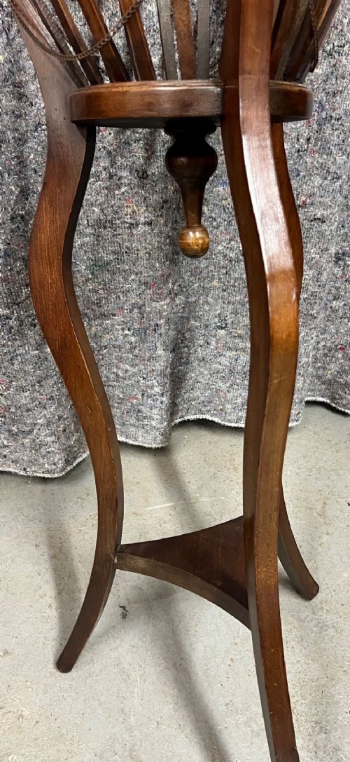 An Edwardian mahogany jardiniere plant stand featuring a slatted circular bucket with internal metal lining, supported by three curved legs and a triangular base stretcher. View VII