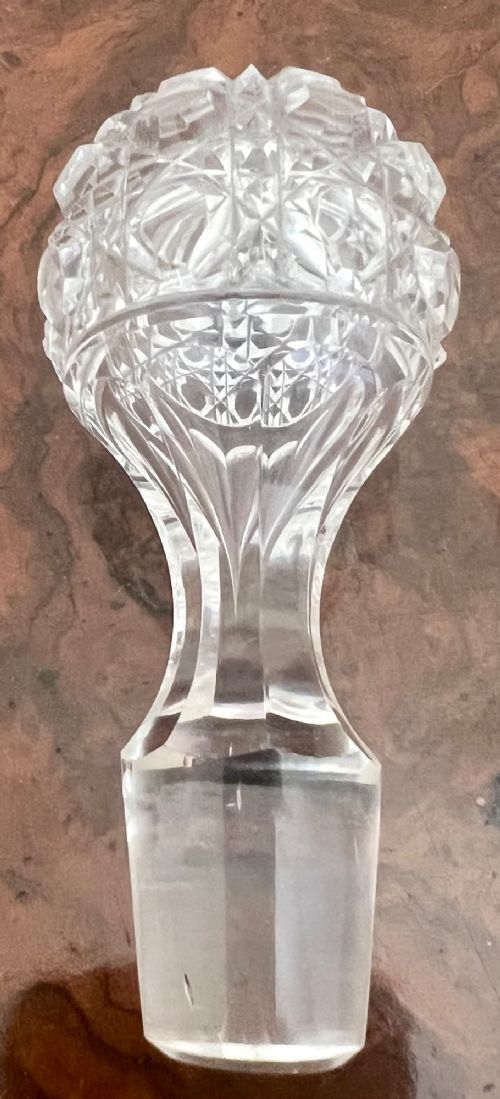 An Edwardian clear cut glass claret jug featuring a diamond-cut pattern body, an elongated handle, and a faceted spherical stopper. View III